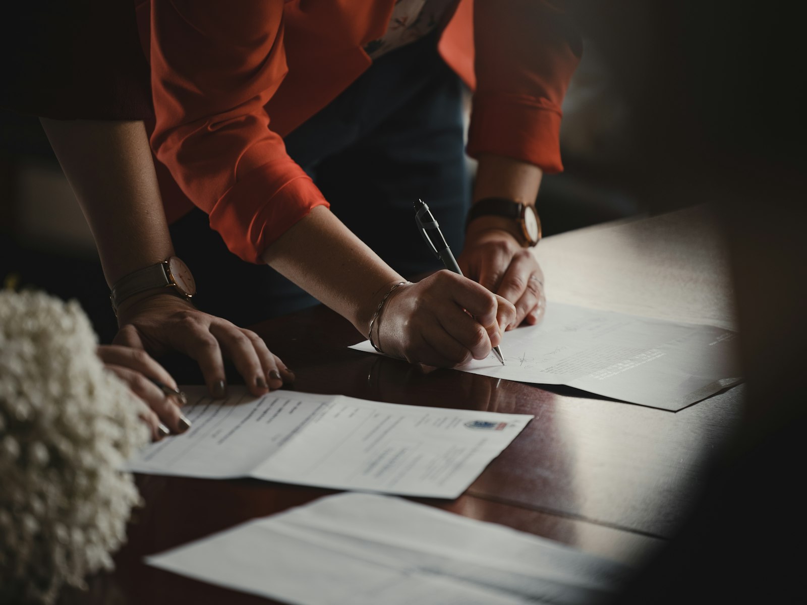 机の上で書類に記入する手元