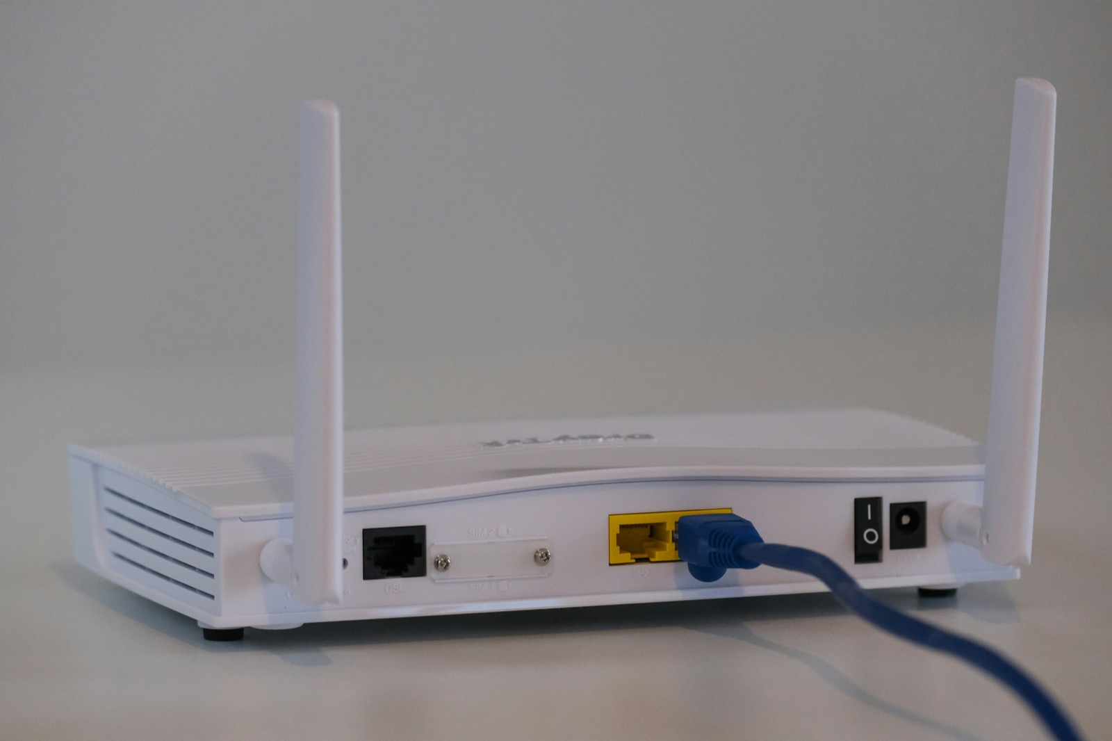 白いテーブルの上に置かれた白いルーター