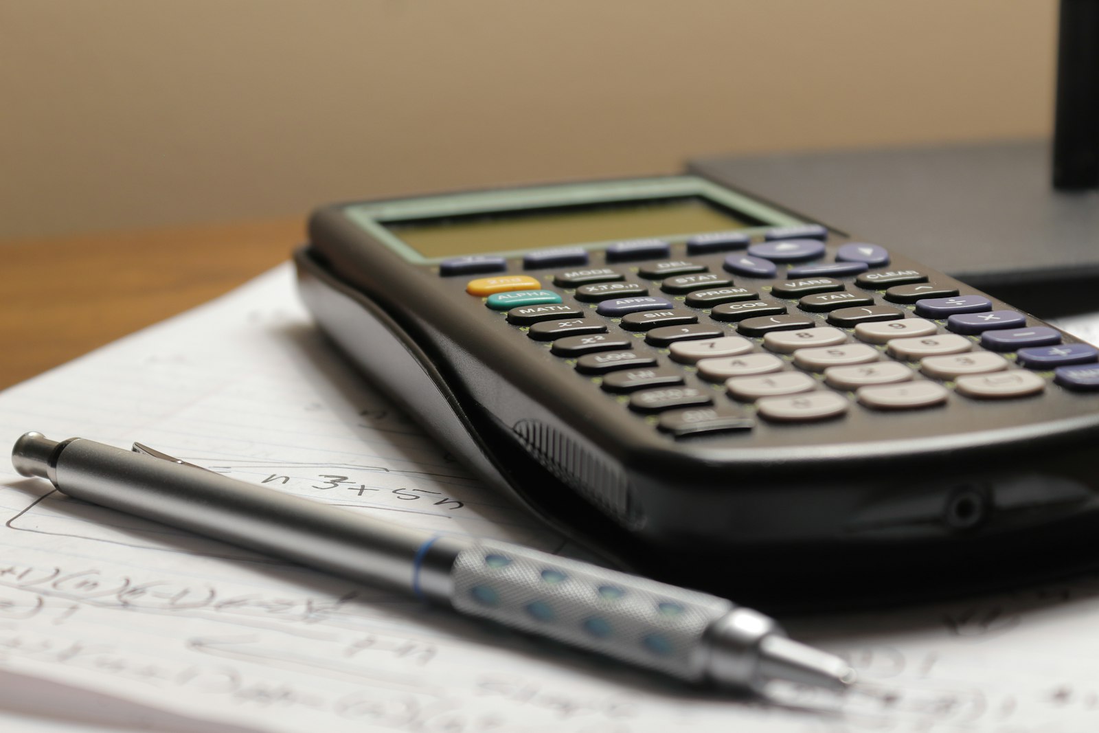 紙の上に置かれた電卓とペン