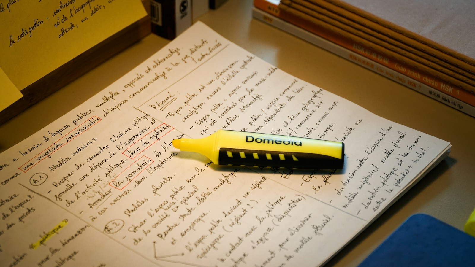 手書きのメモの上に置かれた黄色い蛍光ペン
