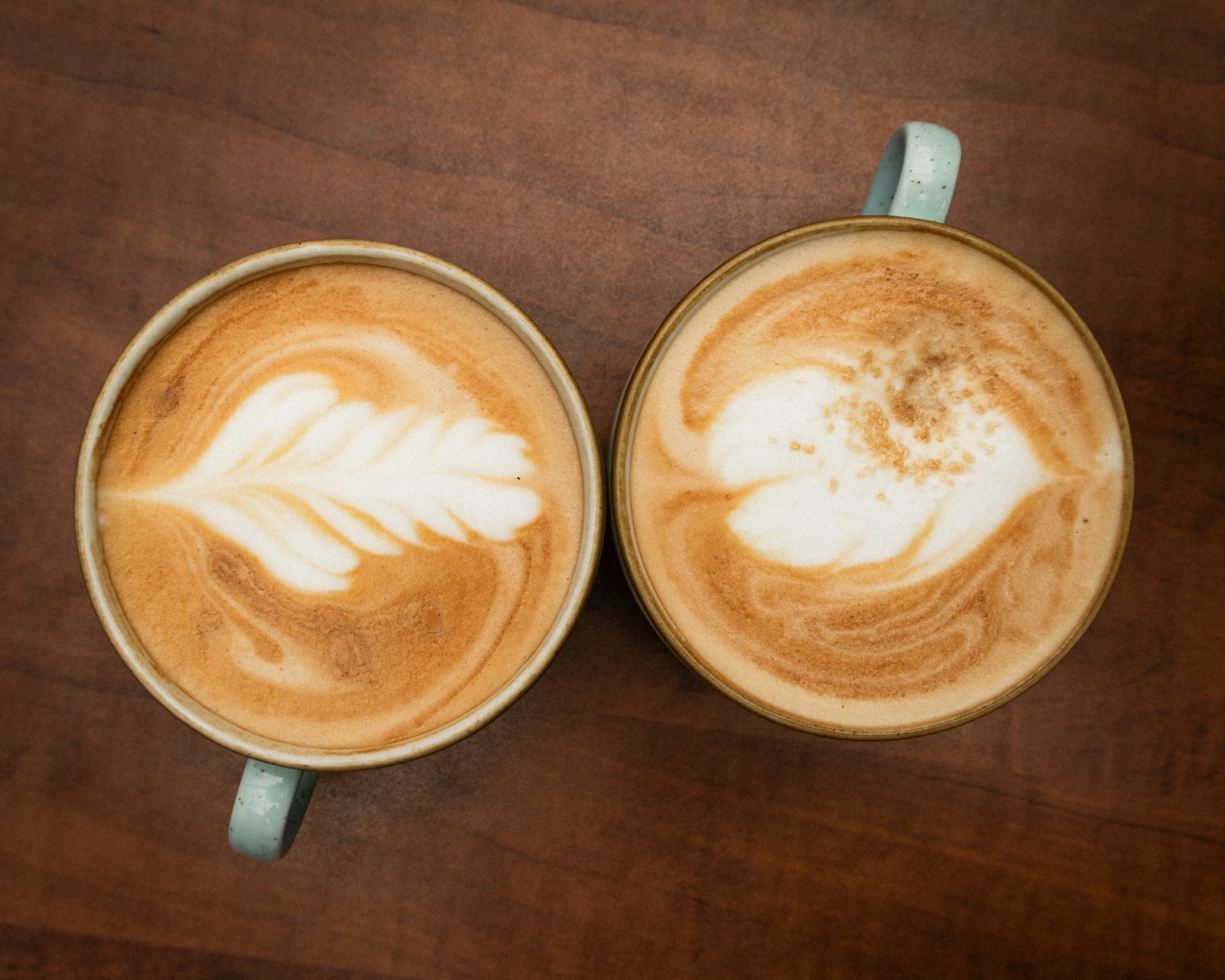 木のテーブルに置かれた2杯のラテ