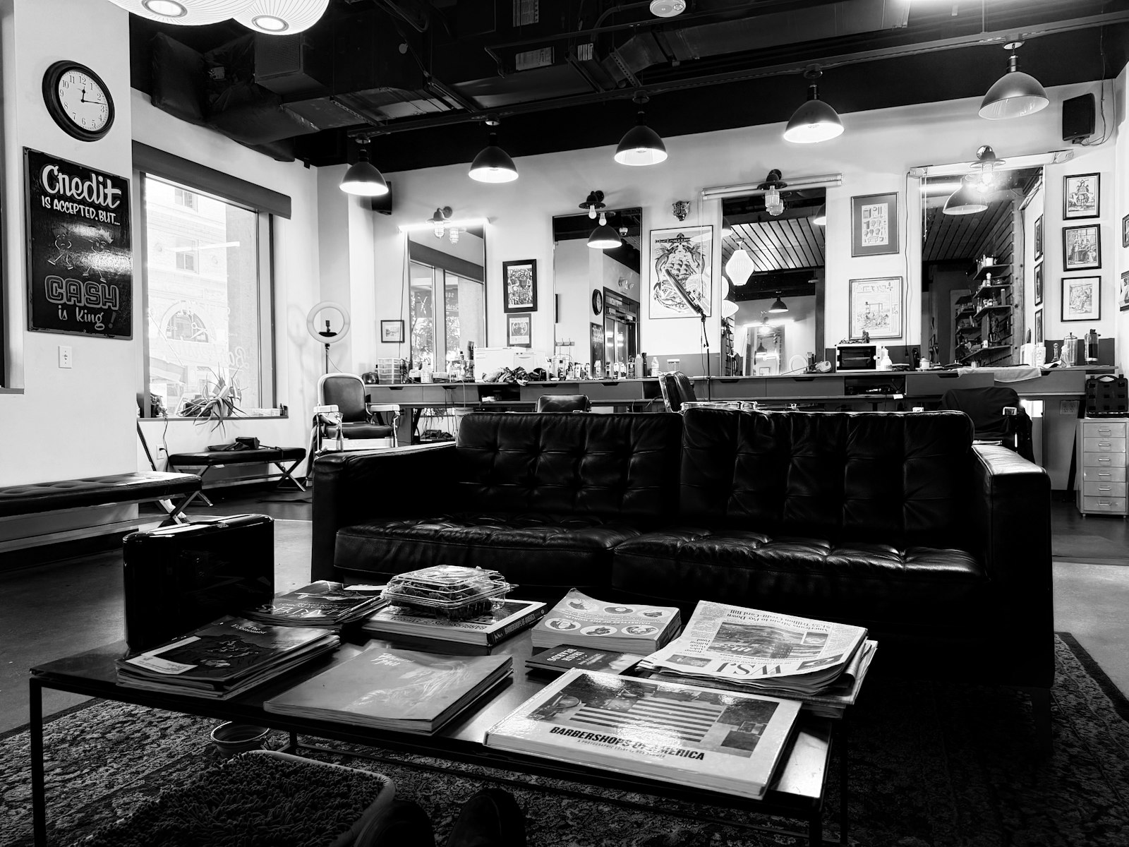 ソファと雑誌が置かれた理髪店の待合